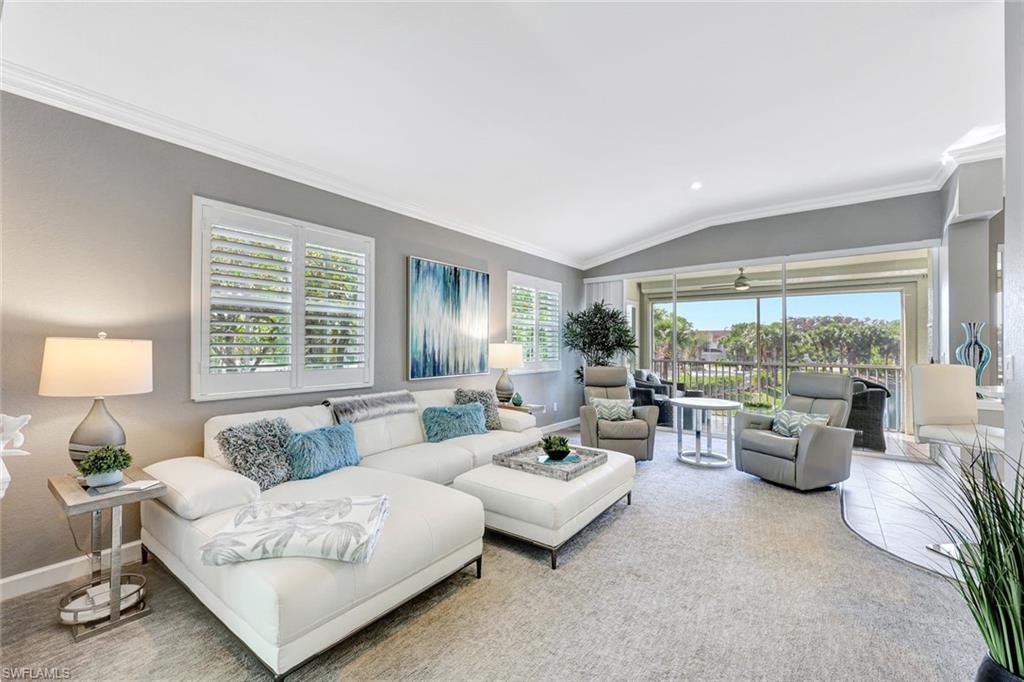 a living room with furniture and floor to ceiling windows