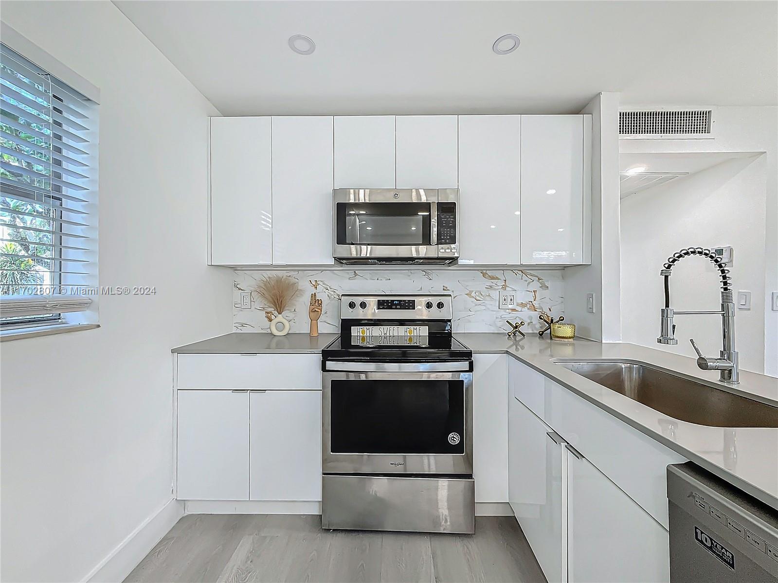 a kitchen with sink a microwave and cabinets