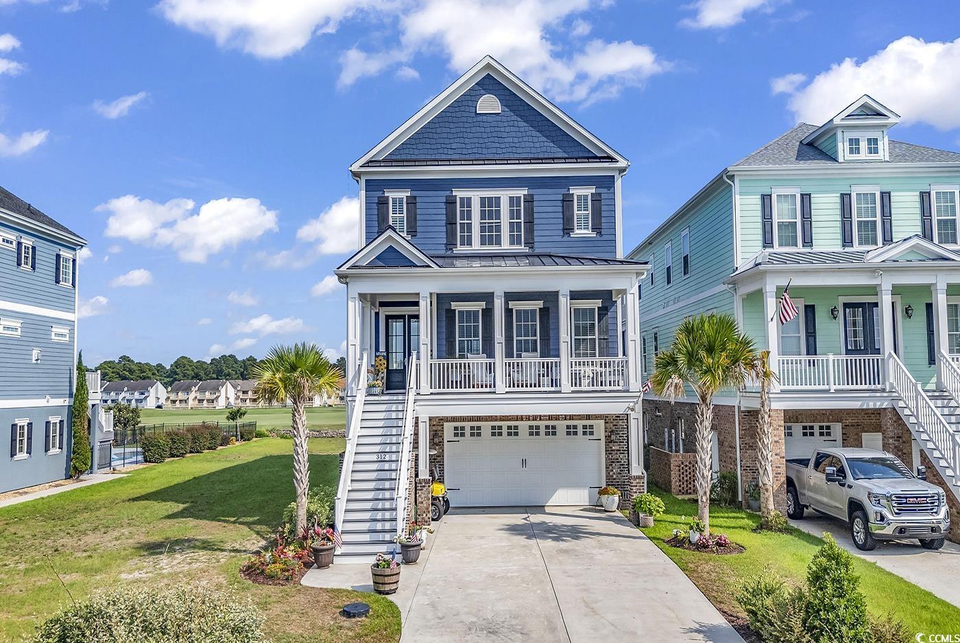 View of front of property with a garage, a porch,