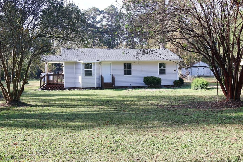 a front view of a house with a garden and trees