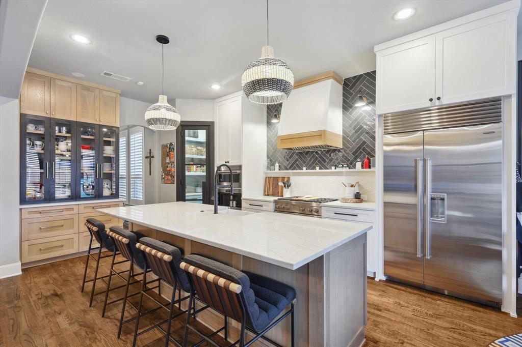 a kitchen with stainless steel appliances granite countertop a table chairs and a refrigerator