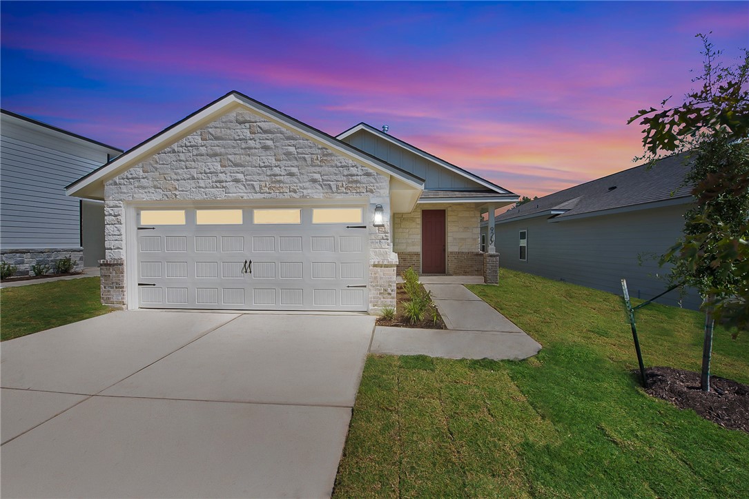 View of front of house with a yard and a garage