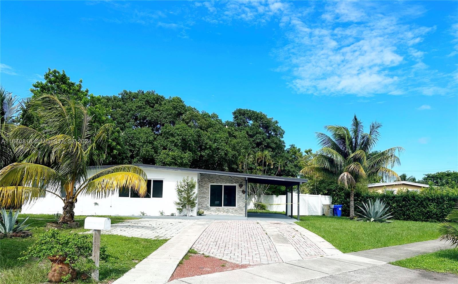 a front view of house with yard and trees in the background