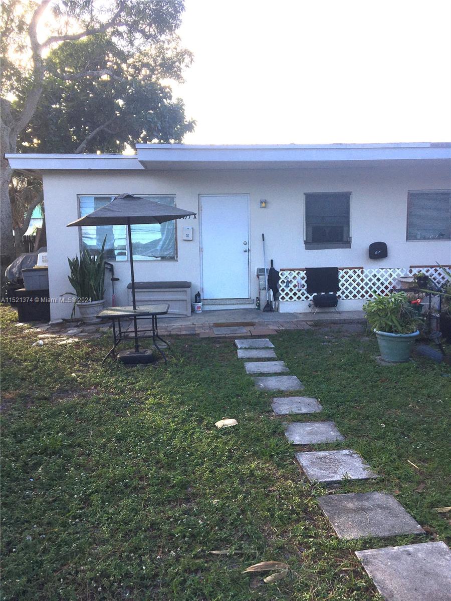 a view of a house with backyard and sitting area