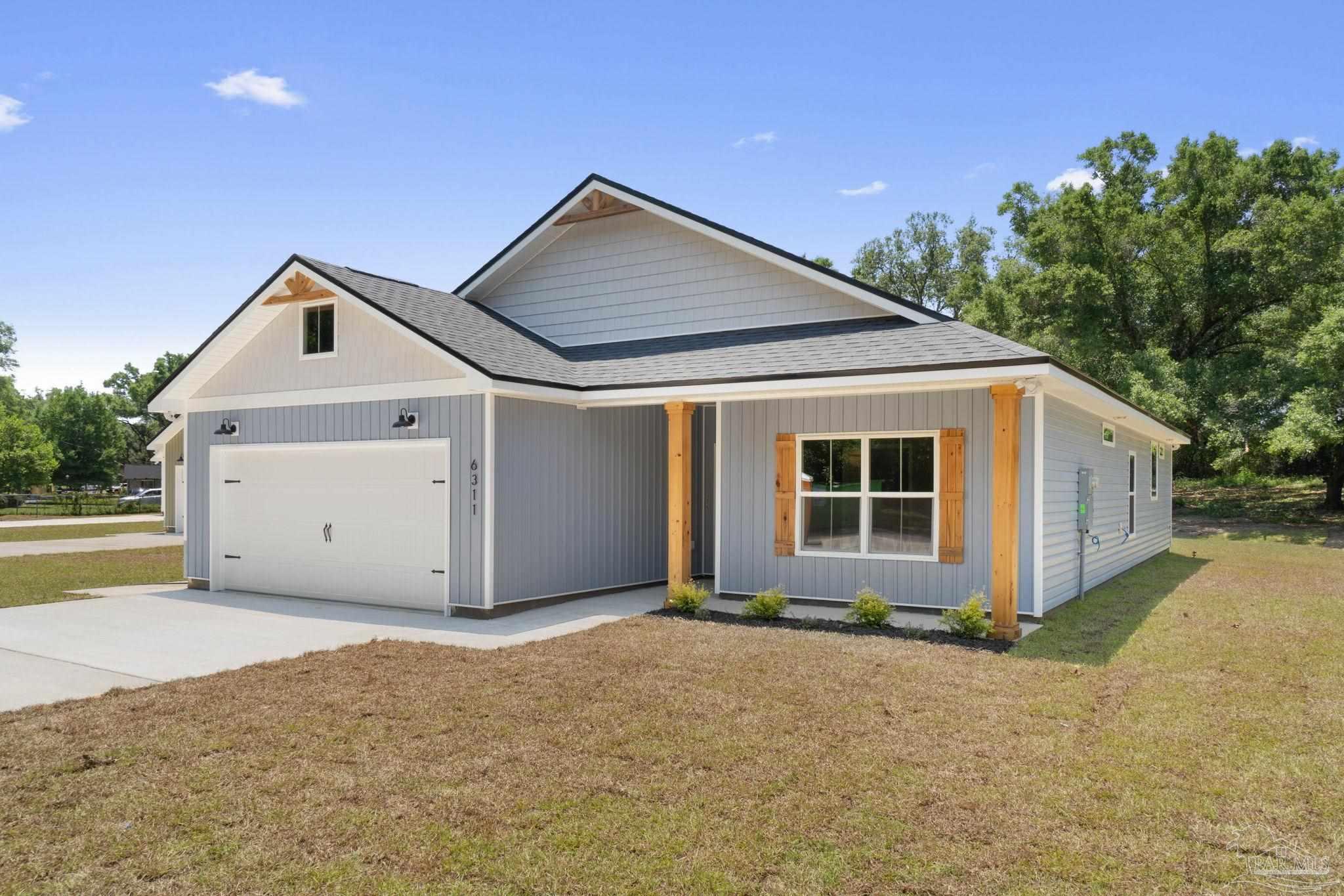 a front view of house with yard and garage