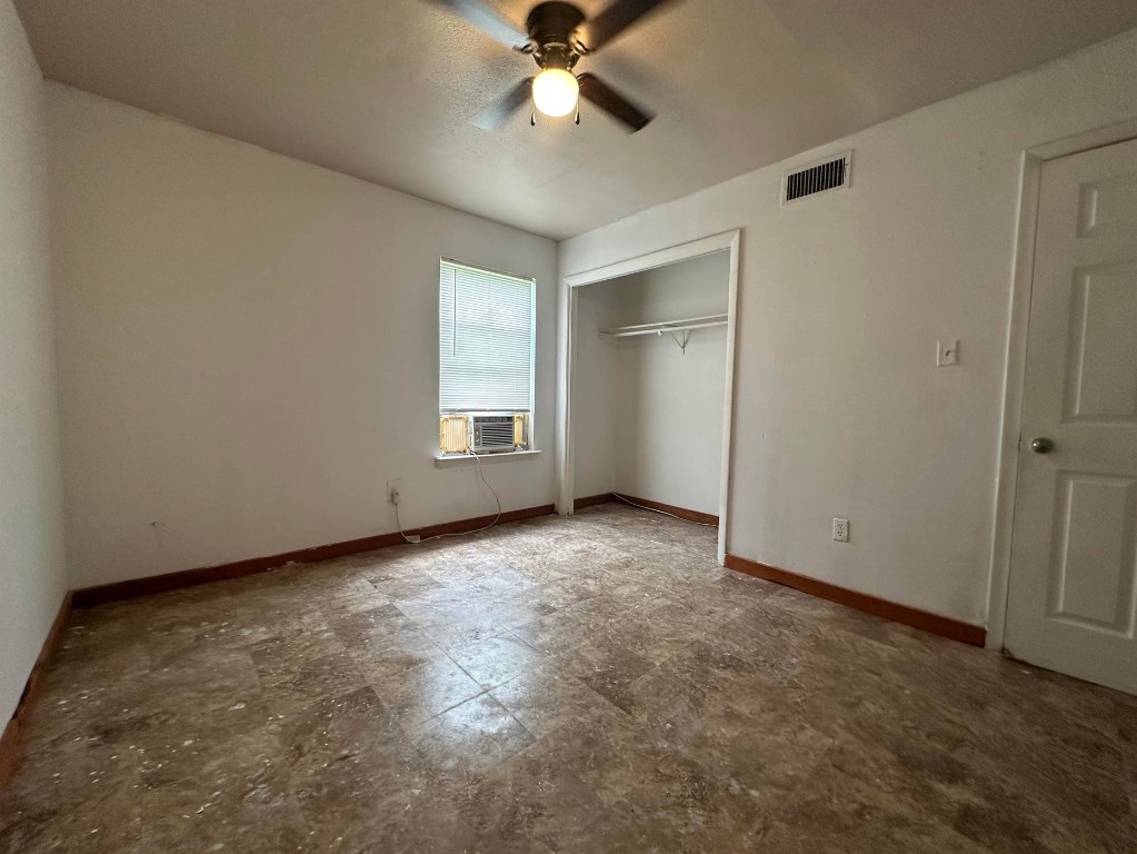 an empty room with closet and windows