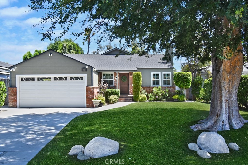 a front view of a house with a garden and yard