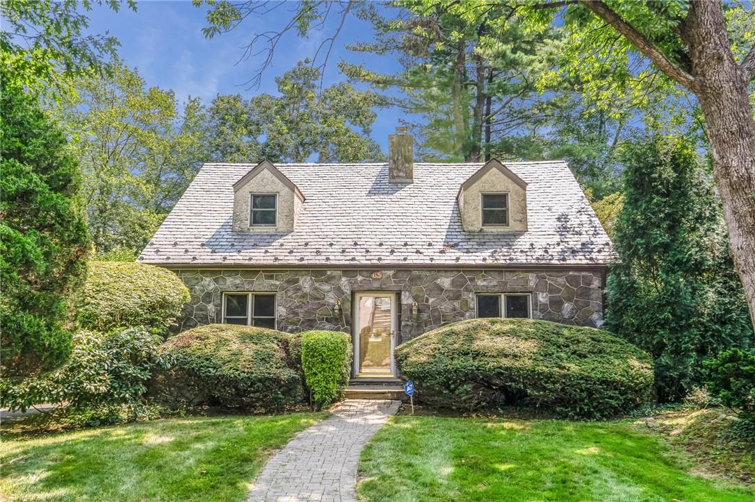 Cape cod-style house featuring a front yard