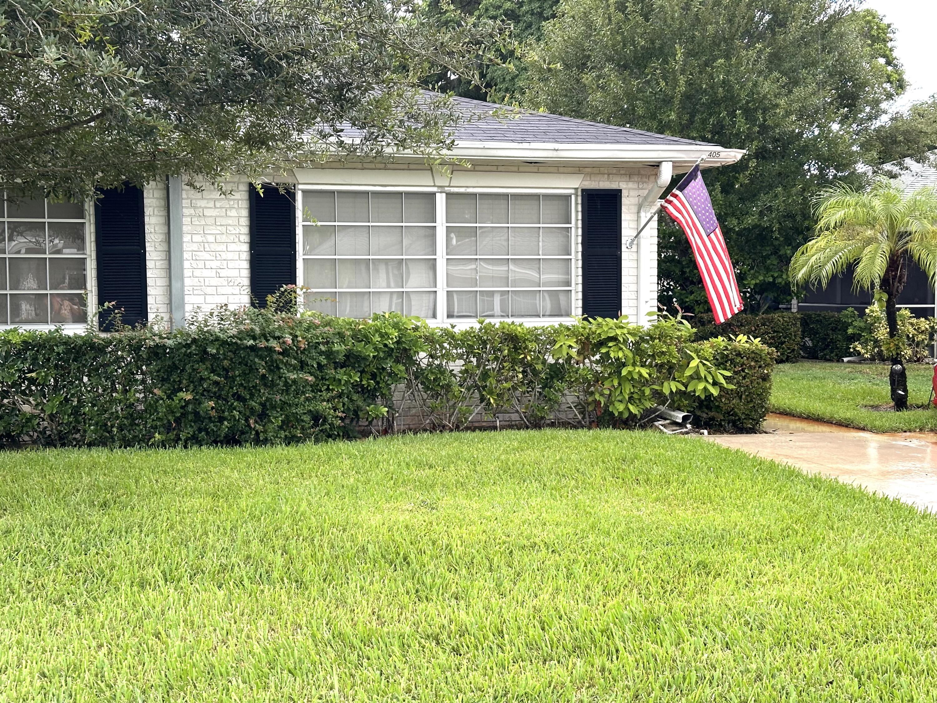 a view of a house with a yard and potted plants