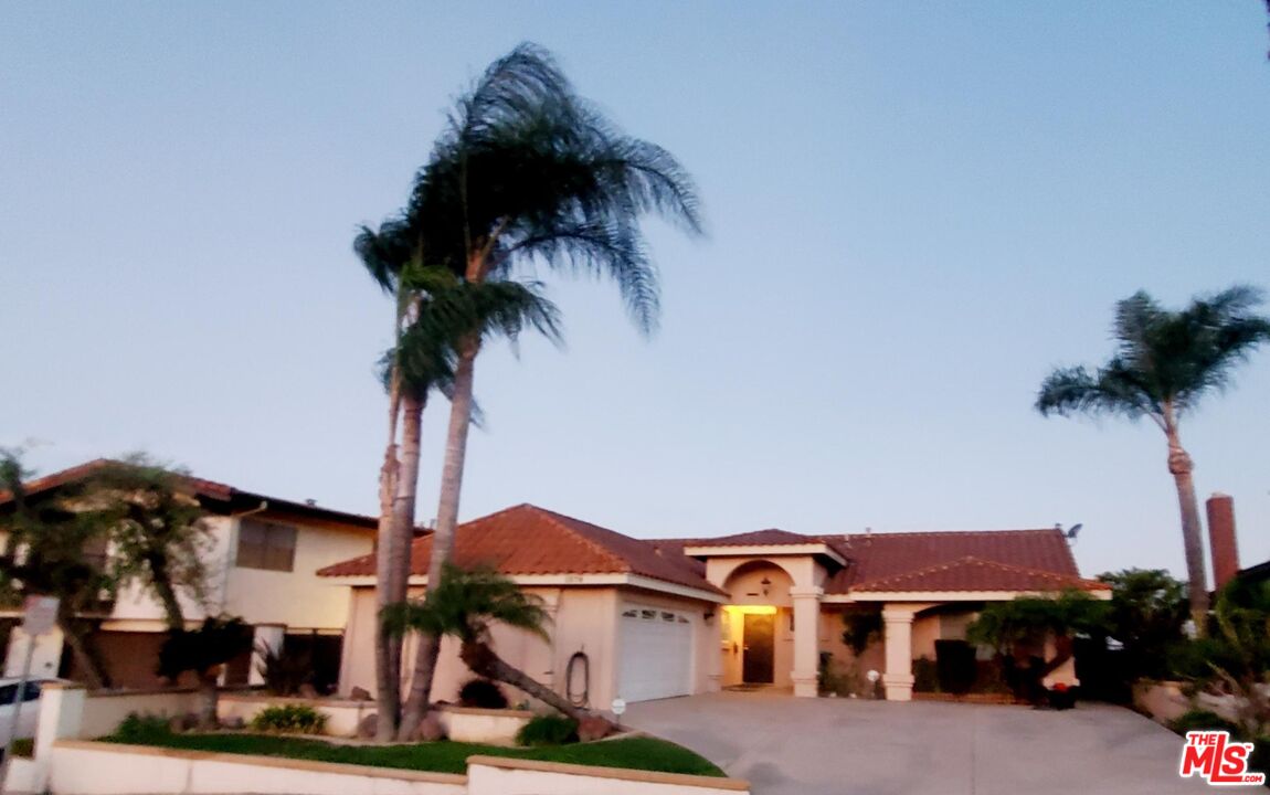 a front view of a house with a garden and plants