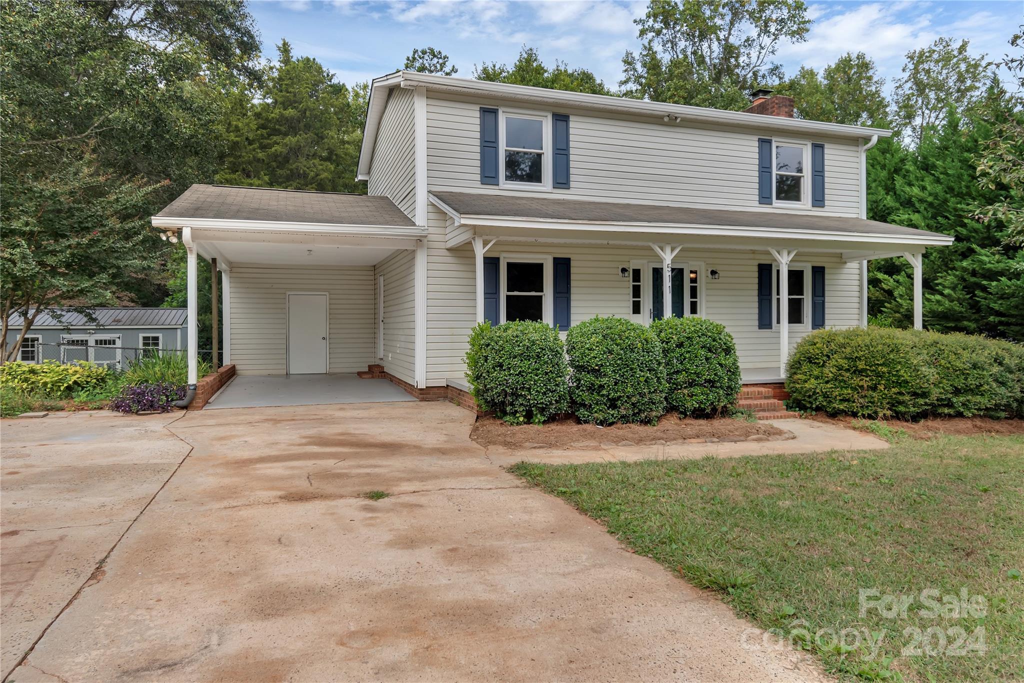 a front view of a house with a yard and trees