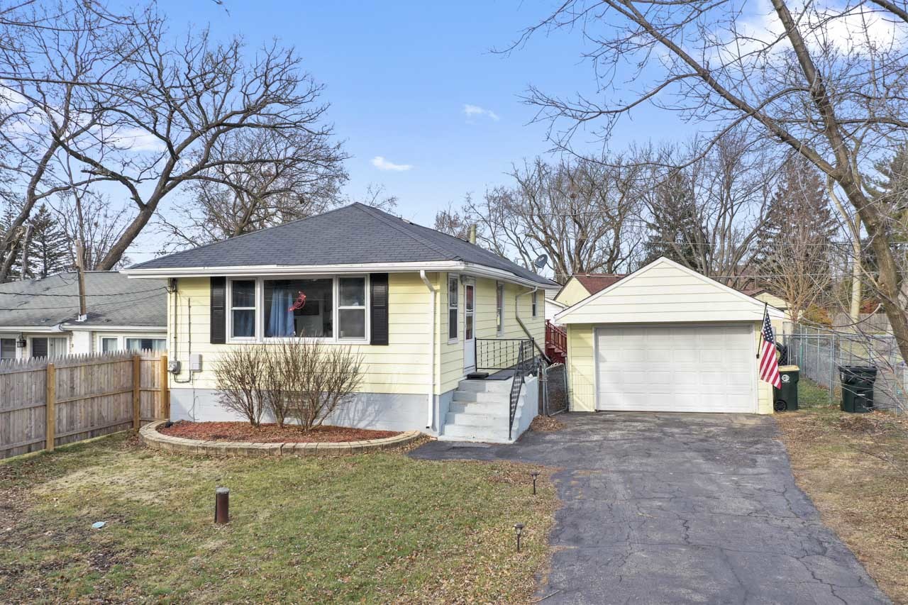 a front view of a house with a yard and potted plants