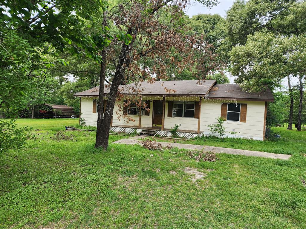 a front view of a house with yard patio and green space