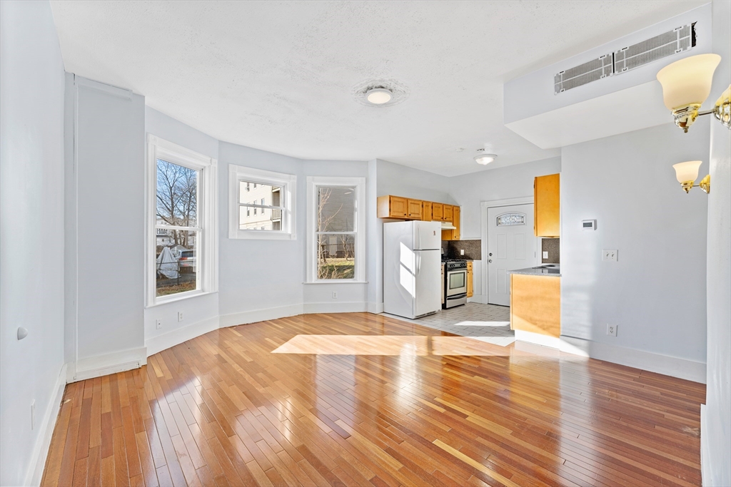 a view of a bedroom with wooden floor and a window