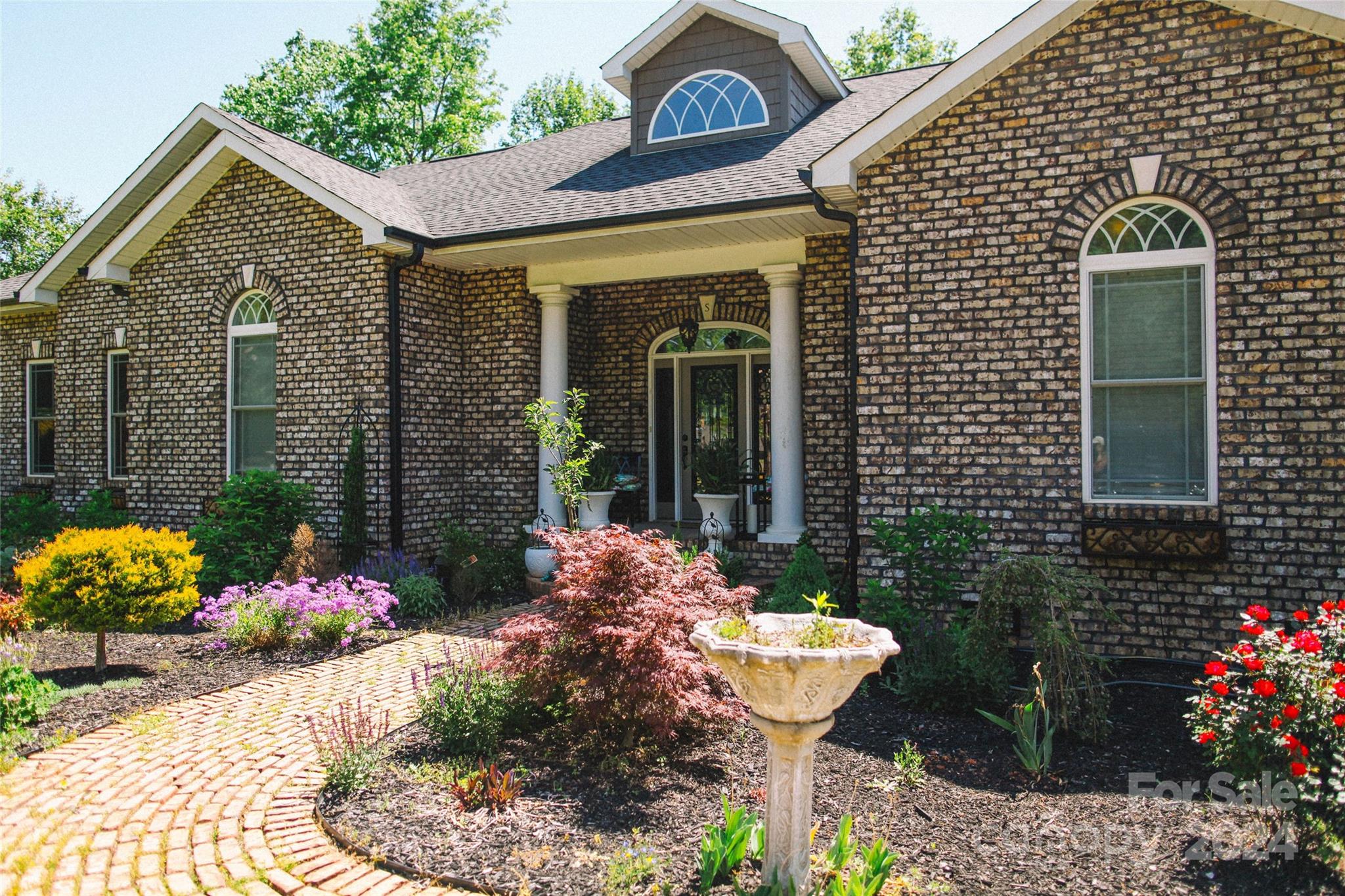 a front view of a house with a garden