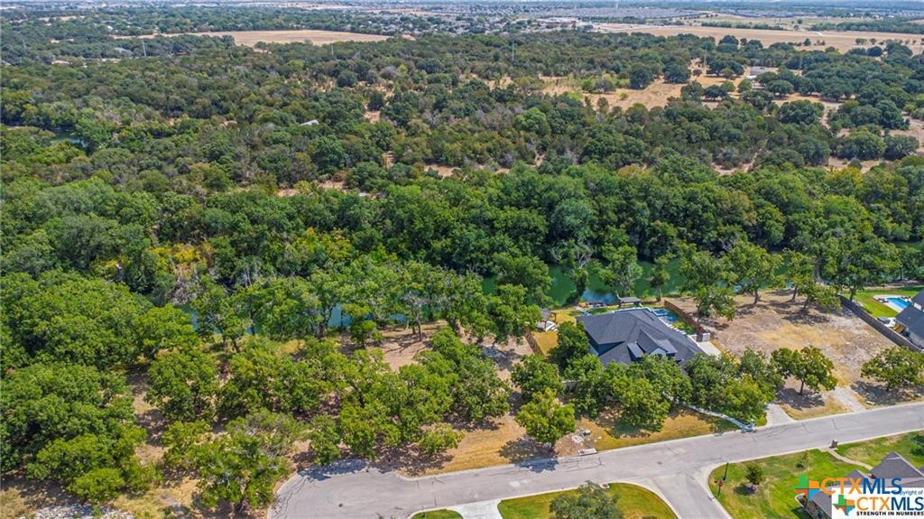 an aerial view of residential house with outdoor space and trees all around