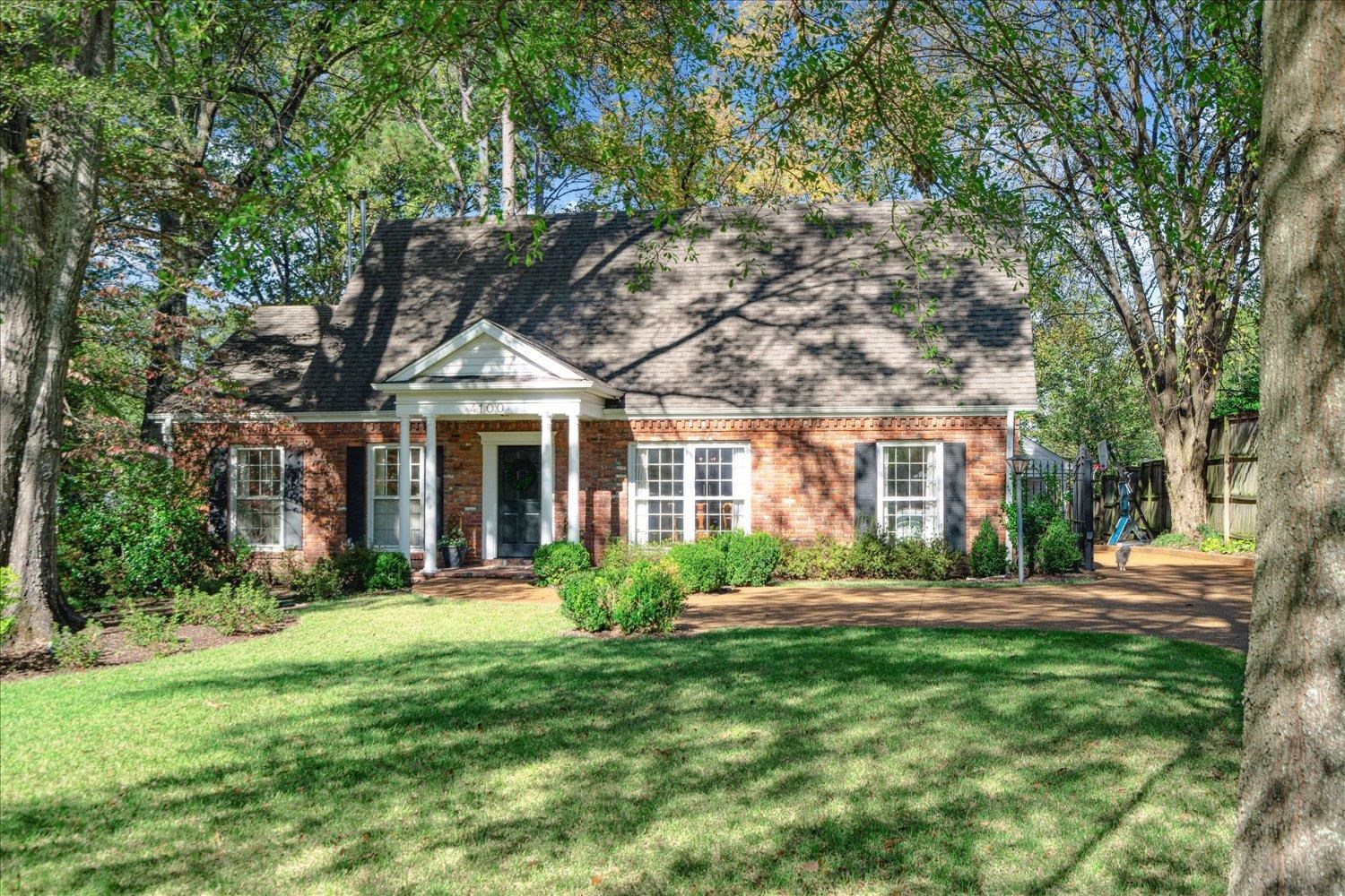 front view of a brick house with a yard