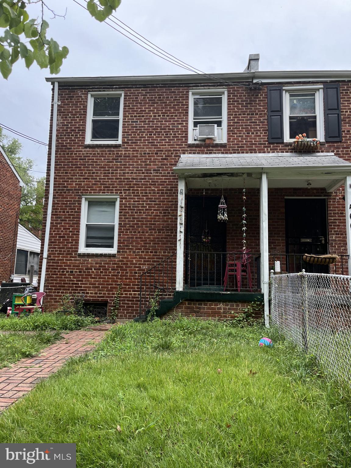 a view of brick house with a large windows and a yard