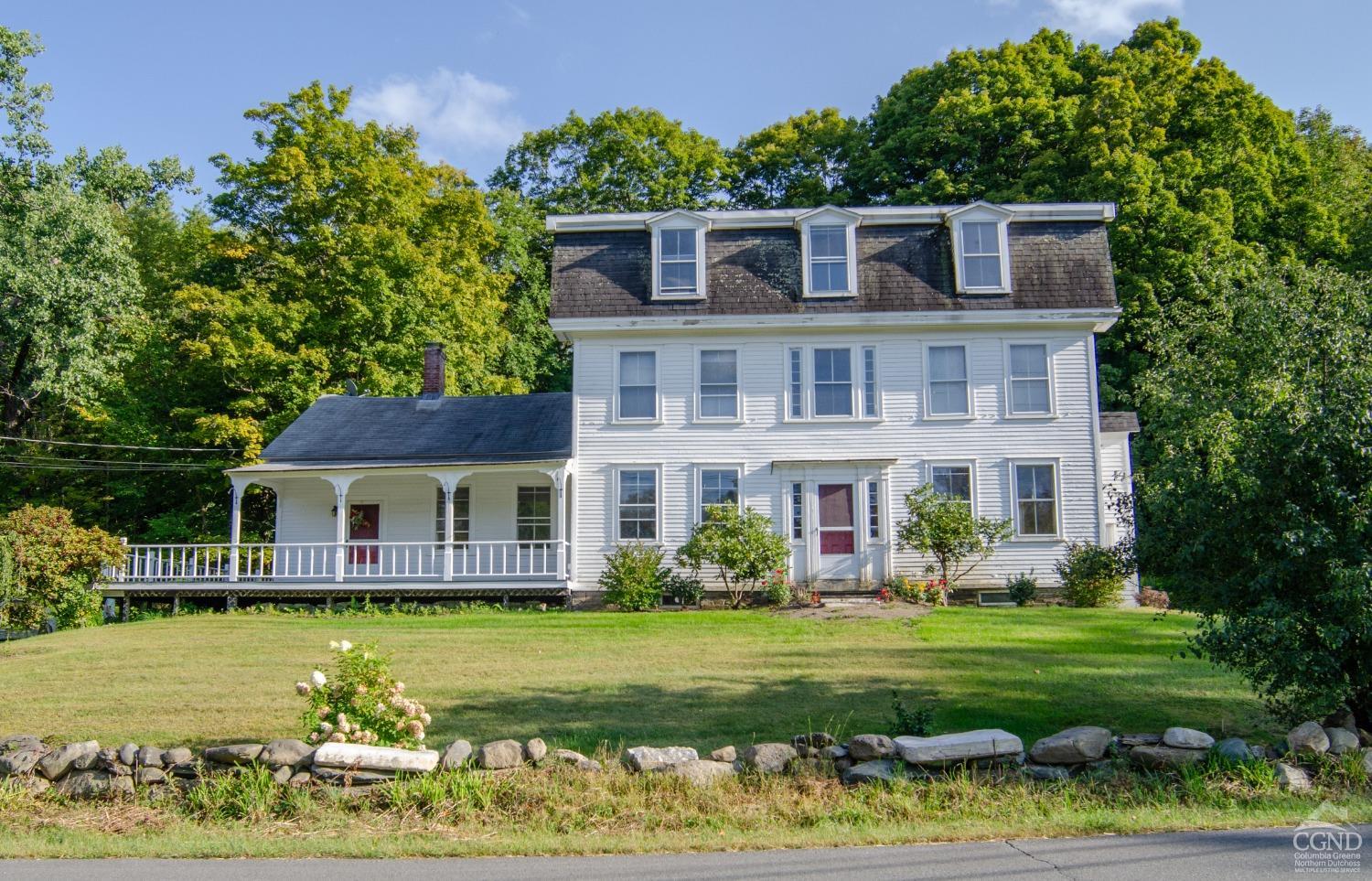 a front view of a house with a garden and swimming pool