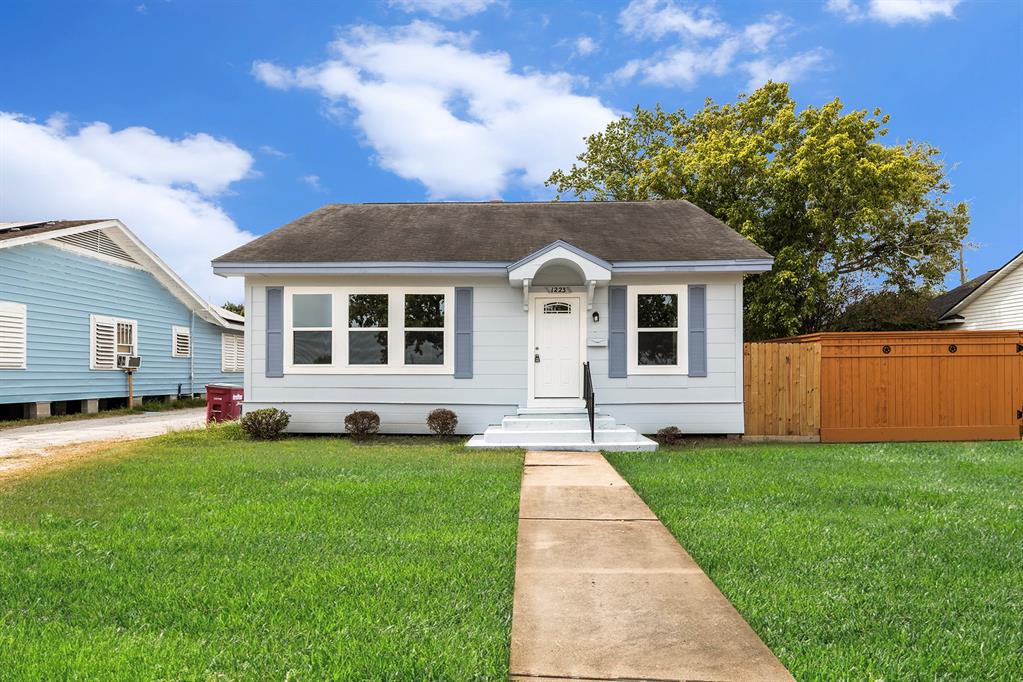 a front view of a house with a yard and trees