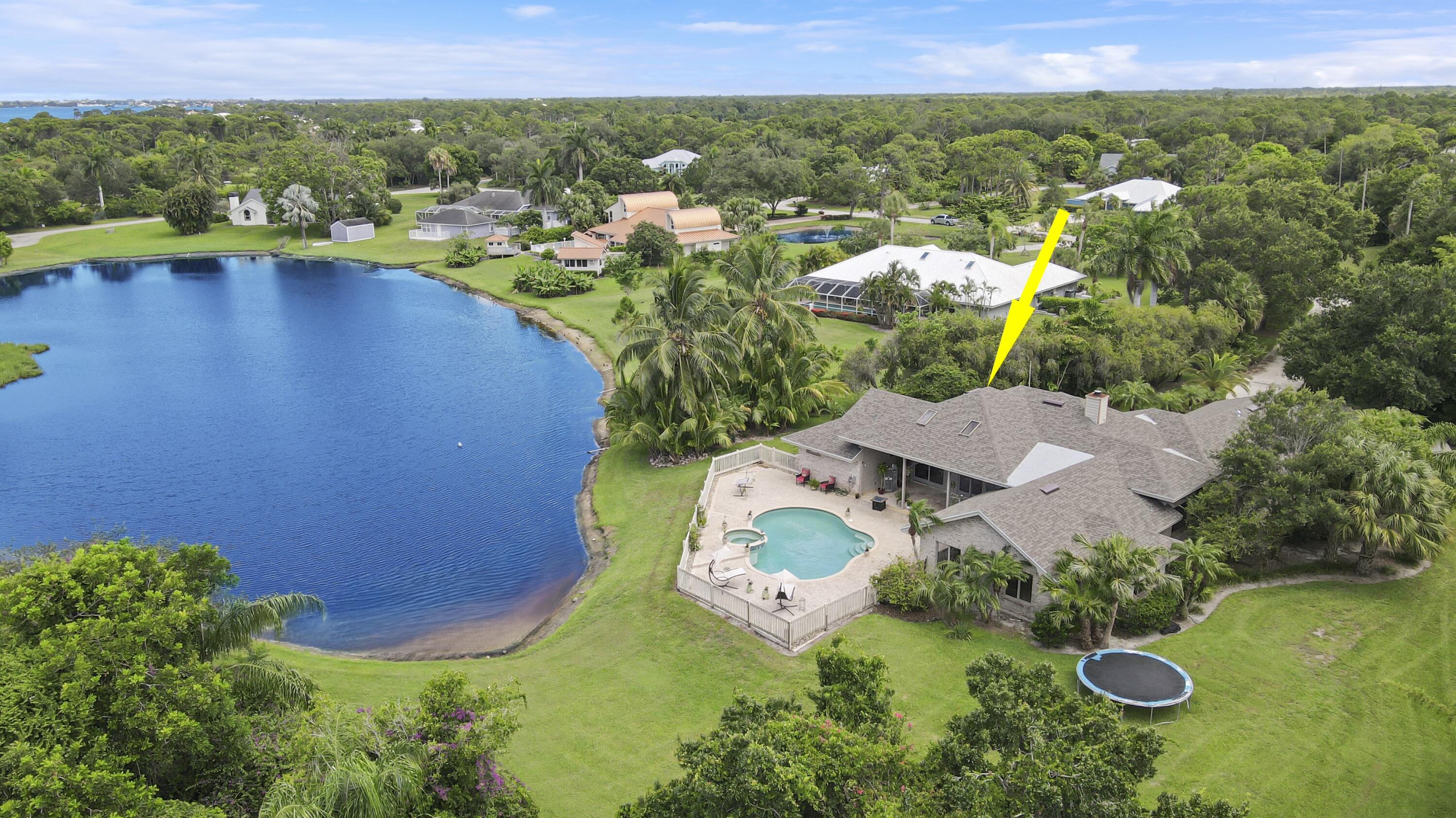 an aerial view of a house with a garden and lake view