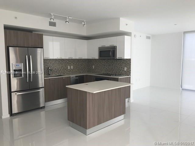 a kitchen with stainless steel appliances a refrigerator and a stove top oven