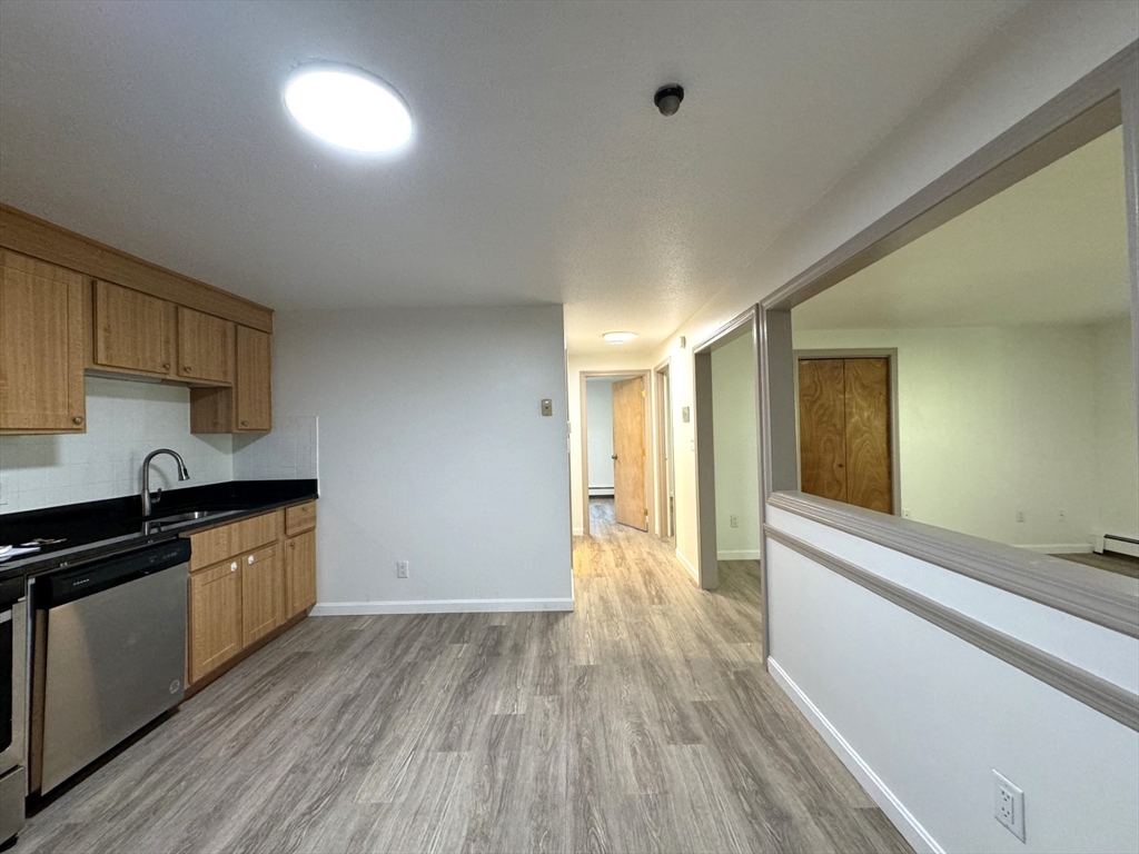 a kitchen with granite countertop wooden floors and wide window