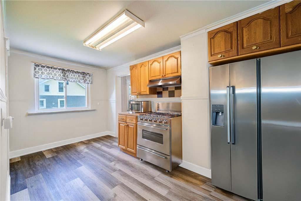 Kitchen with crown molding, stainless steel appliances, and light hardwood / wood-style flooring