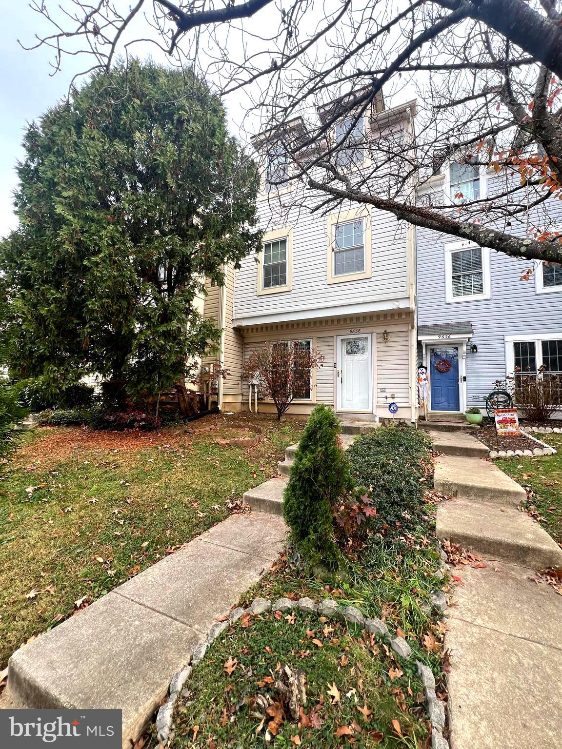 a front view of a house with a yard and trees