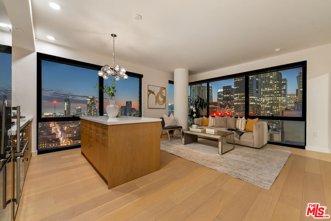 a living room with furniture a flat screen tv and a large window