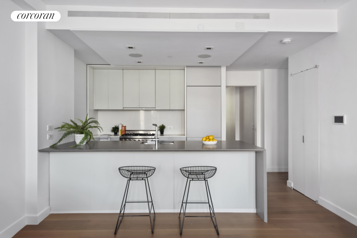 a kitchen with stainless steel appliances a table and chairs in it