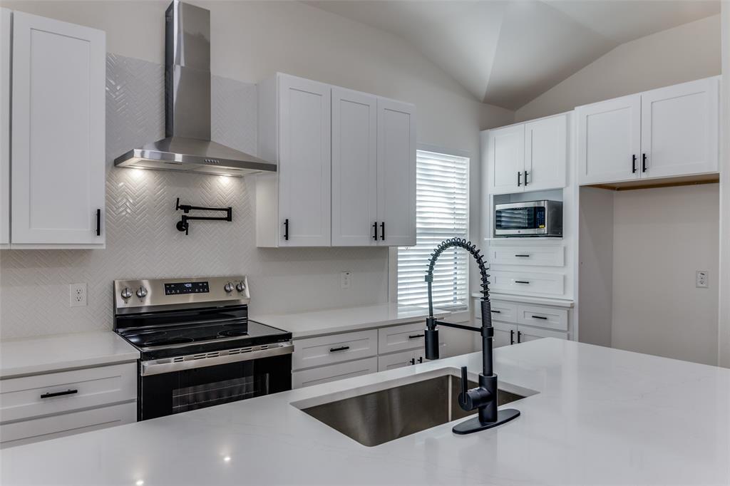 a kitchen with stainless steel appliances a stove sink and cabinets