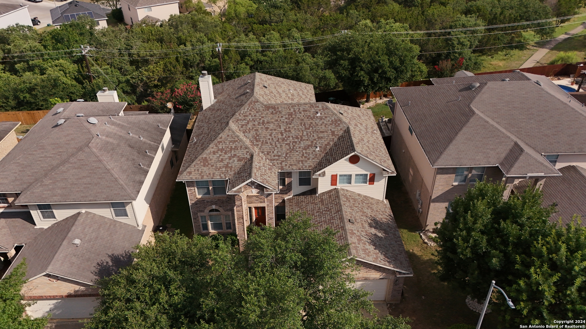 an aerial view of a house with a yard and trees