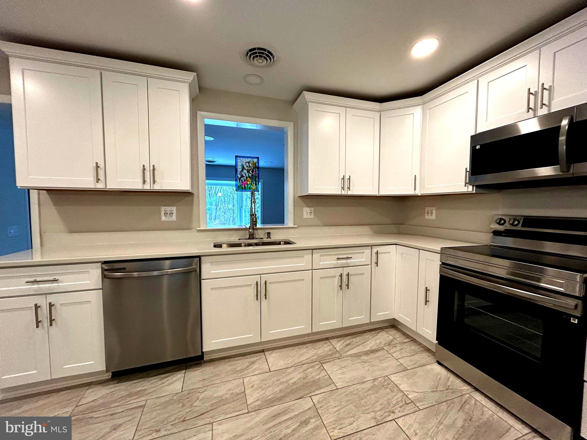 a kitchen with stainless steel appliances granite countertop a stove sink and cabinets