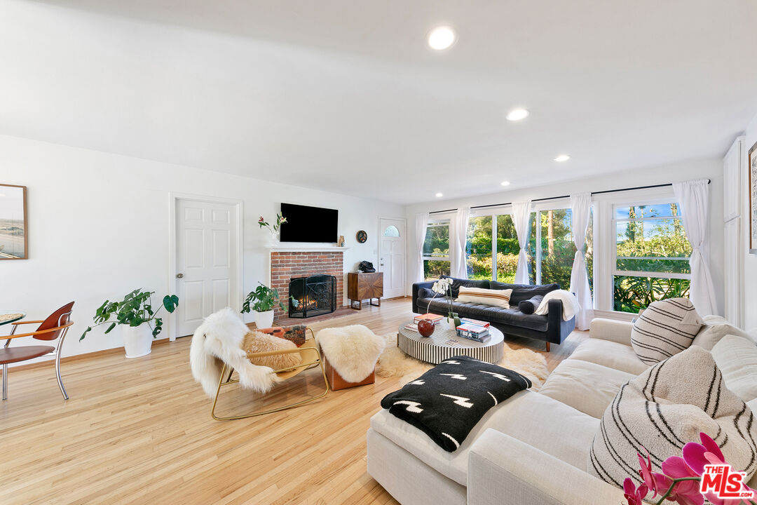 a living room with furniture fireplace and a large window