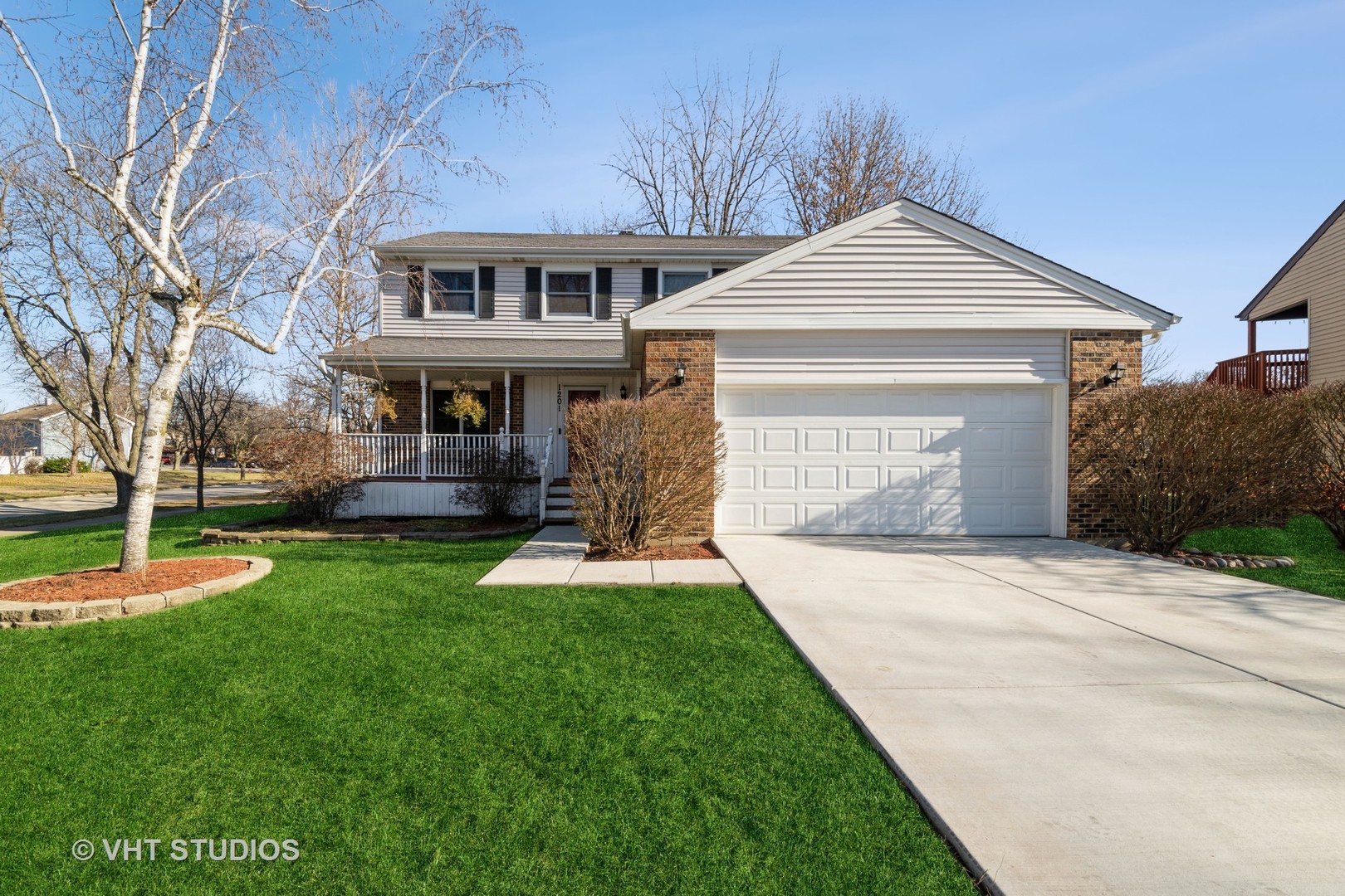 a front view of a house with a yard and trees