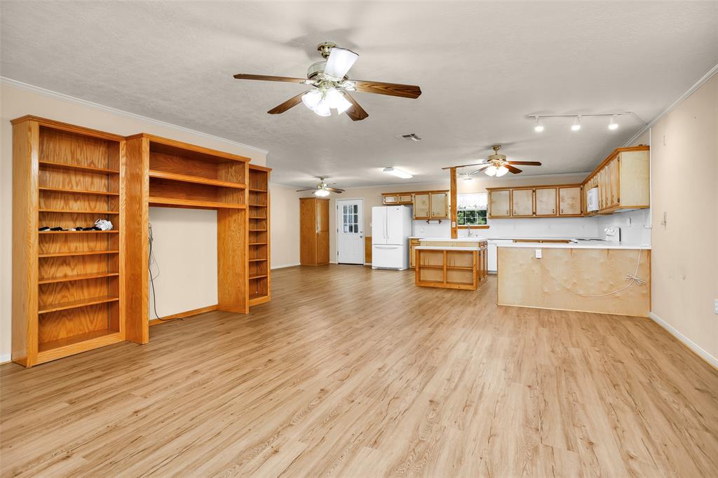 a view of a kitchen with a wooden floor and stainless steel appliances