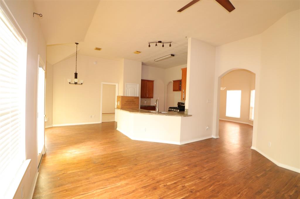 a view of a kitchen with kitchen island a sink wooden floor and a glass door