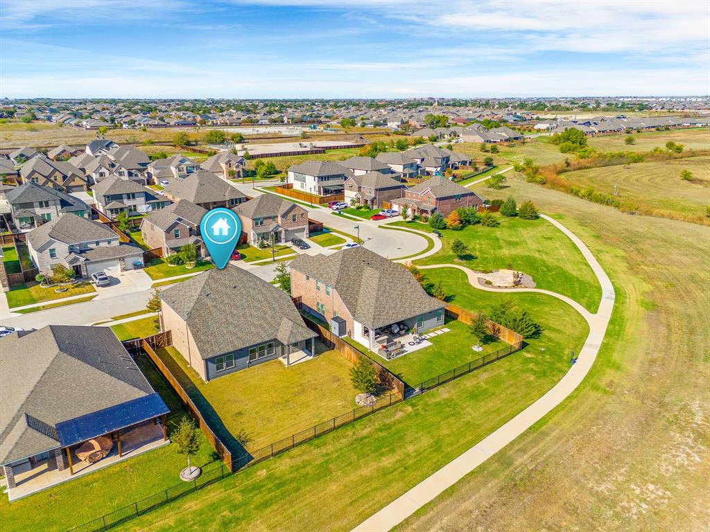 an aerial view of a swimming pool with outdoor seating and yard in back