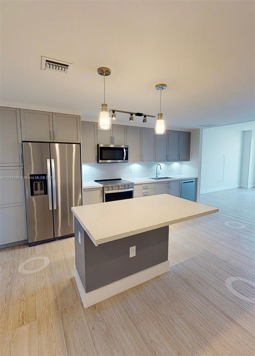 a kitchen with stainless steel appliances a refrigerator and a stove