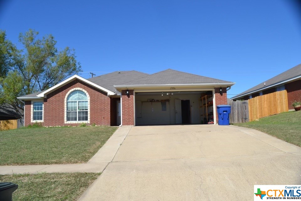 a front view of a house with yard garage and outdoor seating