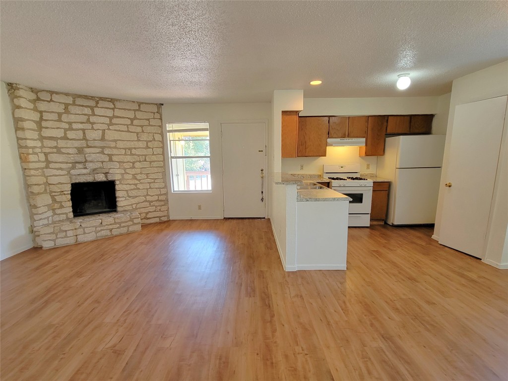 a kitchen with a wooden floor and a refrigerator