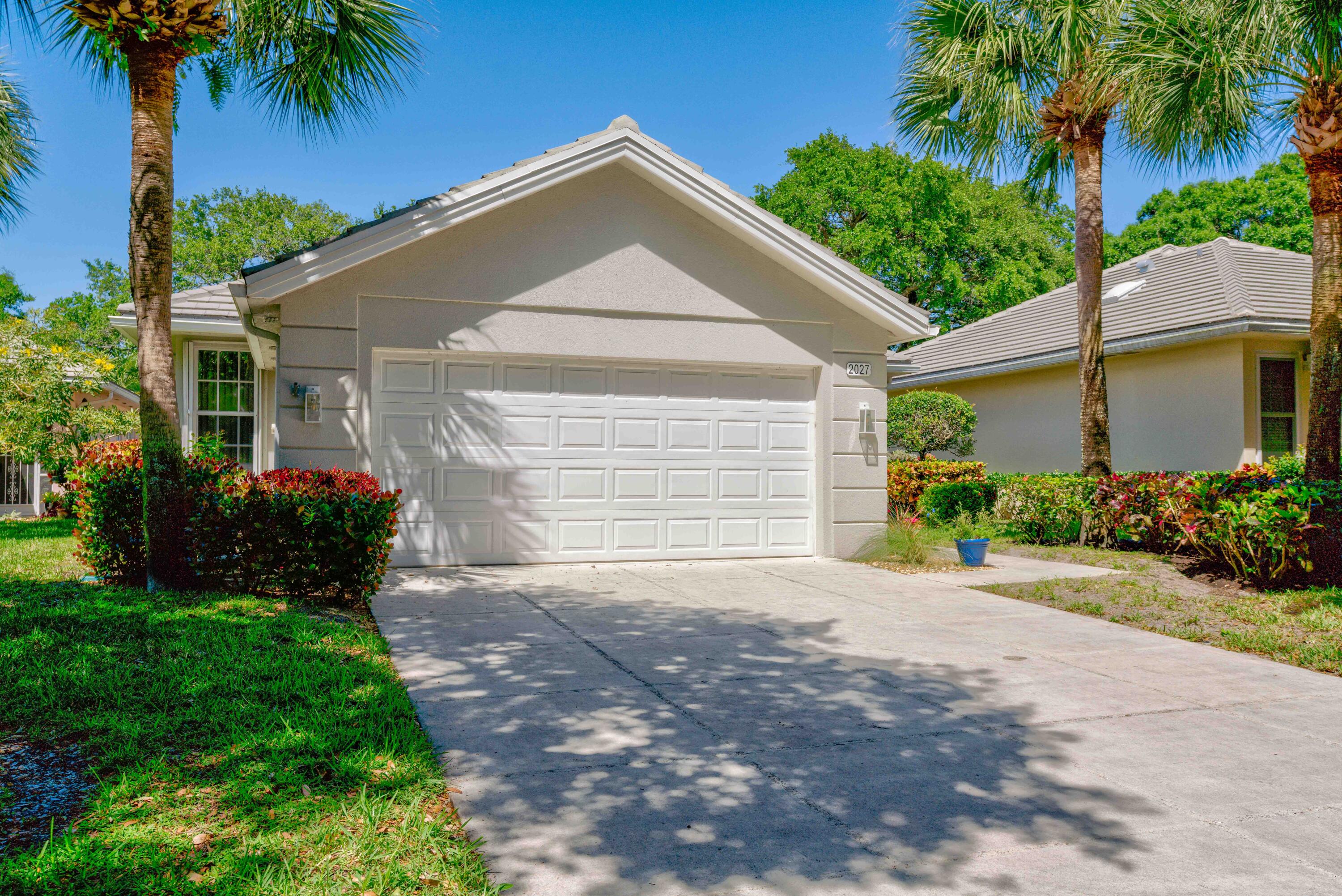 a front view of a house with a yard and a garage