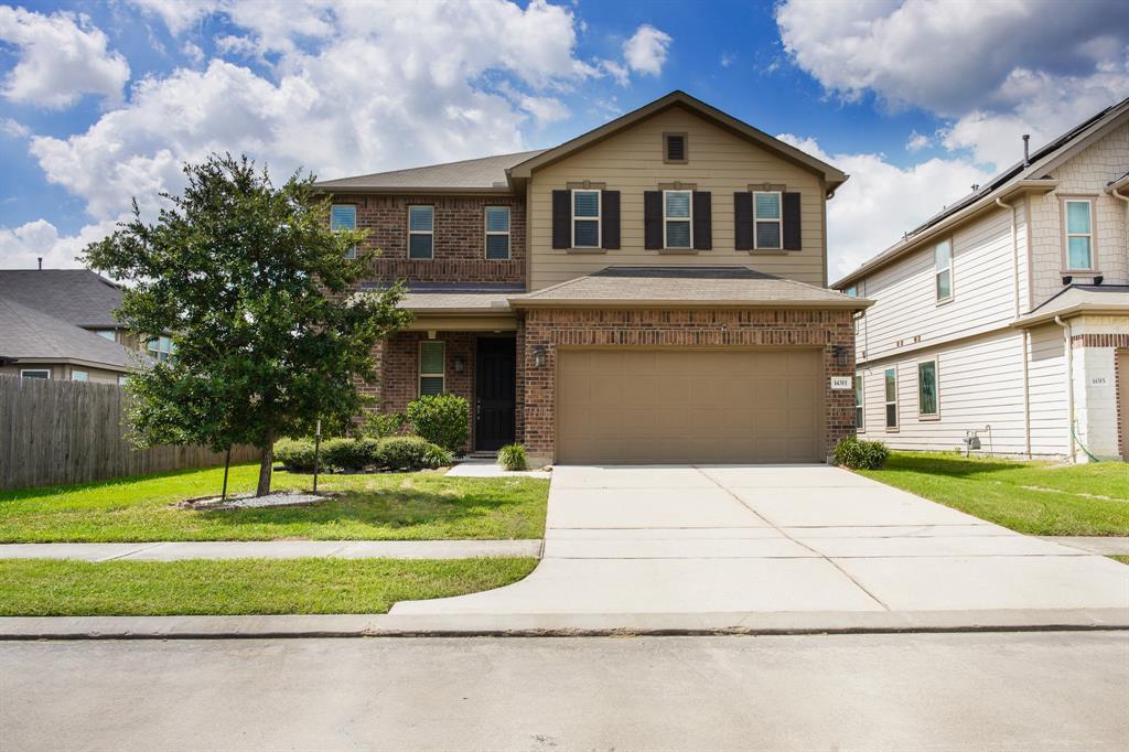 Beautiful two-story home featuring an attached two-car garage, a well-maintained lawn and a sidewalk leading to a covered front entryway.