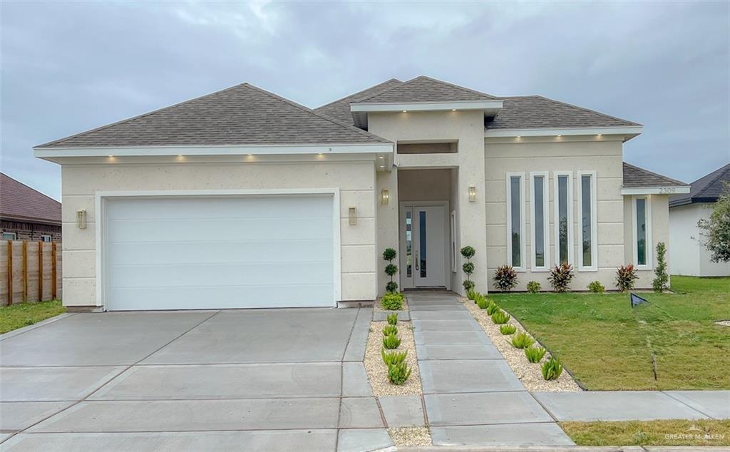 Prairie-style home with a garage and a front lawn