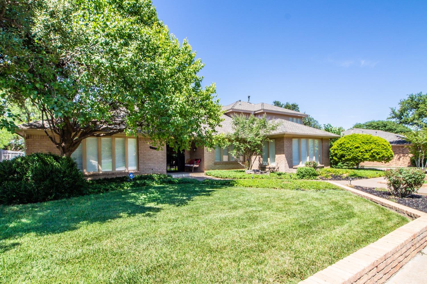 a front view of a house with a yard and trees