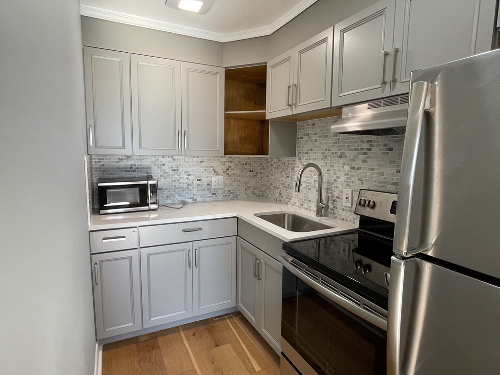 a kitchen with a sink stove and refrigerator