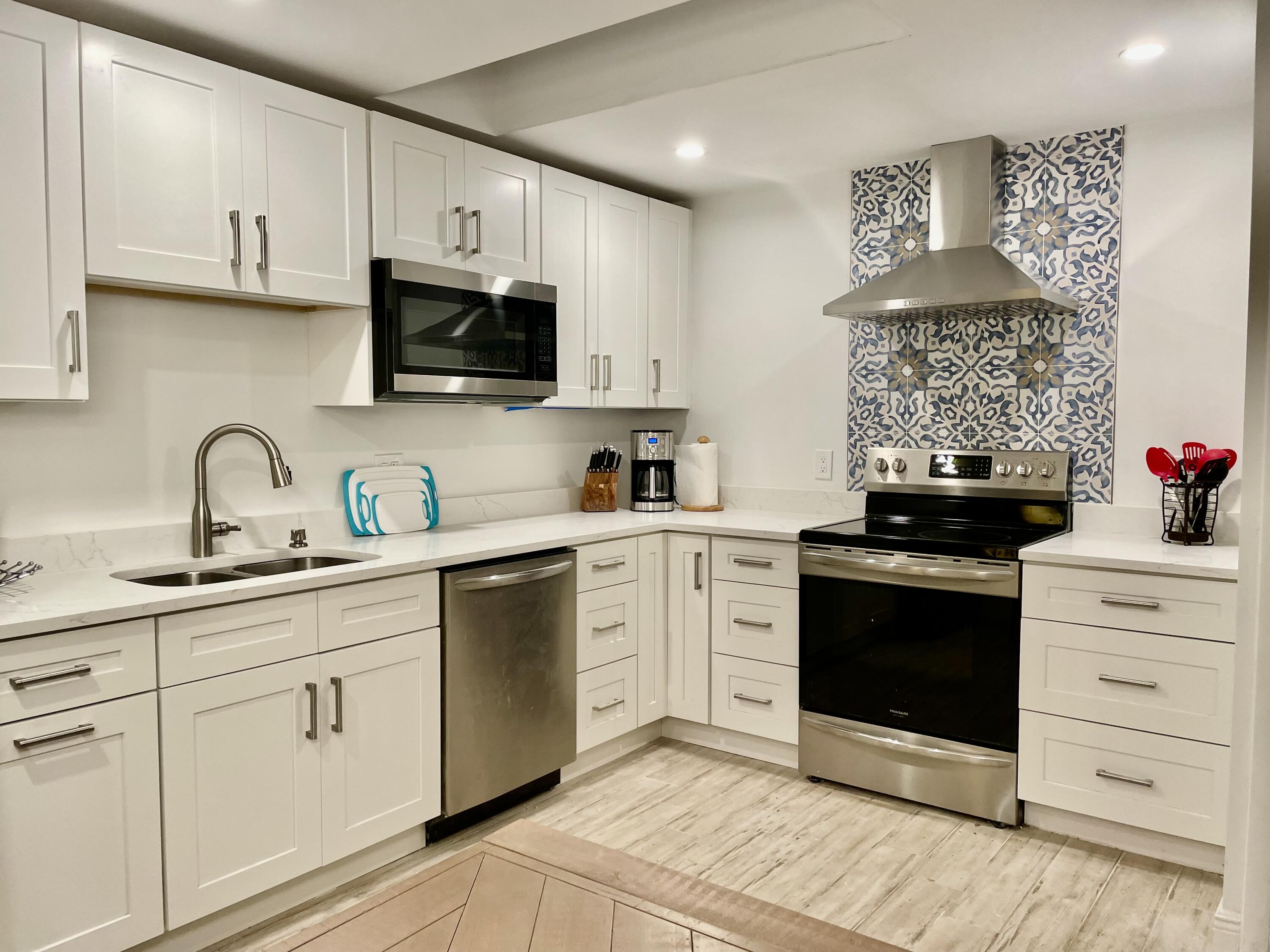 a kitchen with white cabinets stainless steel appliances and sink