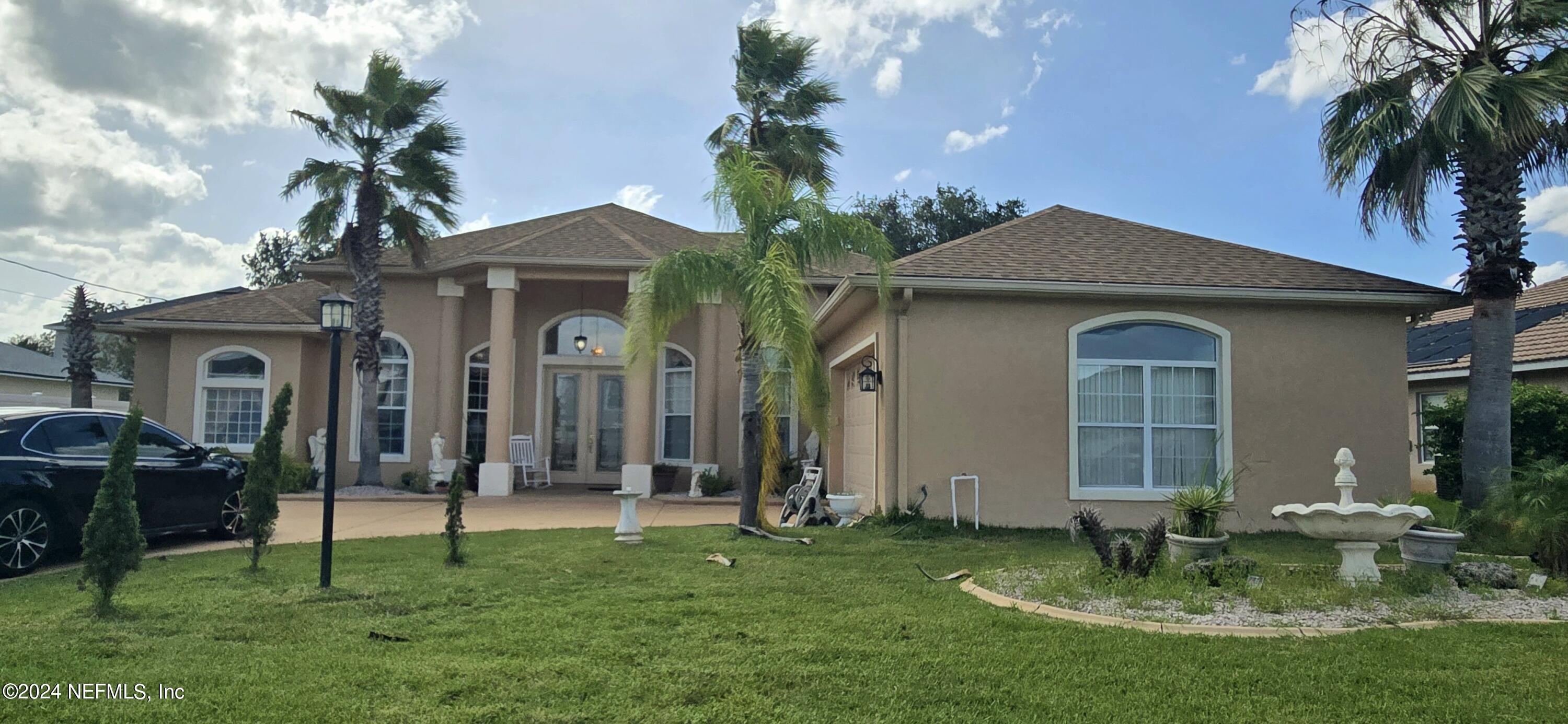 a front view of a house with a garden