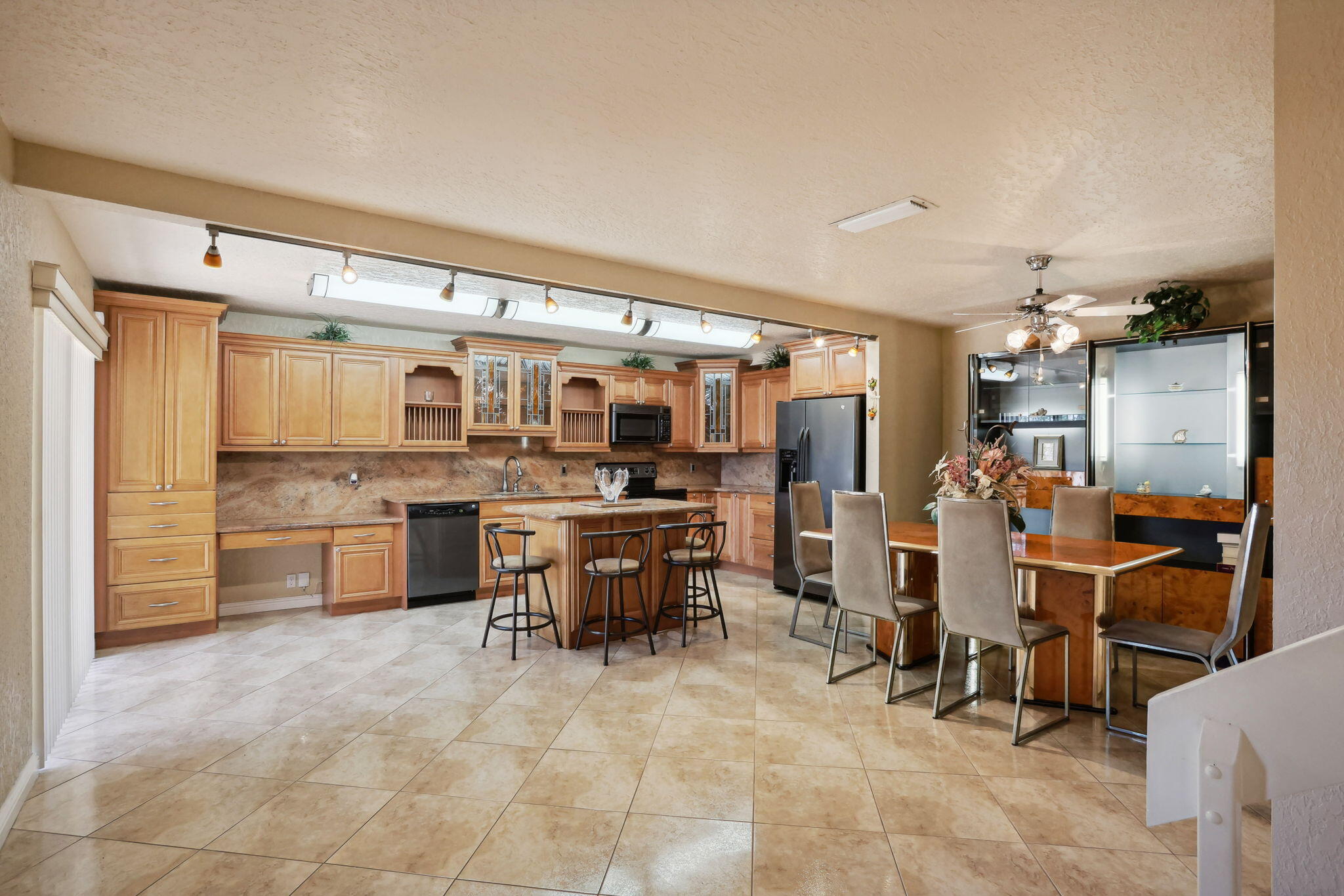 a open kitchen with stainless steel appliances kitchen island granite countertop a refrigerator and cabinets